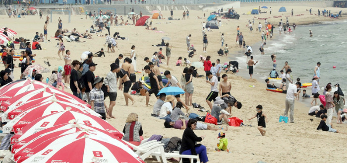 Beachgoers at Busan's Haeundae Beach, which opened on June 1, flock there to avoid the summer heat. (Yonhap News)