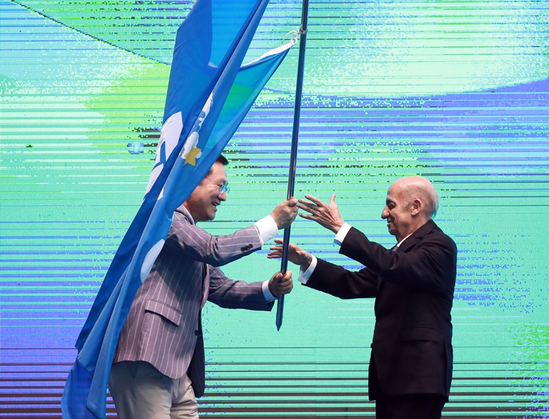 Gwangju Mayor Lee Yong-sup (left), who served as the chairman of the Organizing Committee for the FINA World Championships Gwangju 2019, on July 28 hands the FINA flag over to FINA President Julio Maglione (right) in the tornament's closing ceremony at Nambu University Municipal Aquatics Center. (Yonhap News)