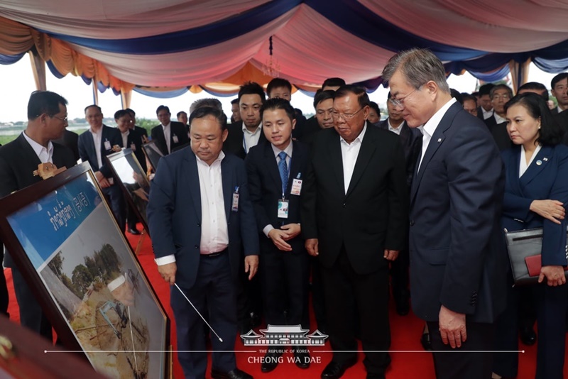President Moon Jae-in and Lao President Bounnhang Vorachith on Sept. 5 listen to a progress report at a business site around the Mekong River in the Lao capital of Vientiane. (Cheong Wa Dae)