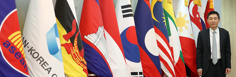 ASEAN-Korea Centre Secretary General Lee Hyuk poses with the national flags of Korea and ASEAN member states. He said his goal is to make Korea and ASEAN close neighbors through people-to-people exchange.