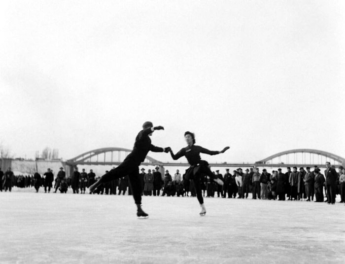 In 1956, visitors to the Hangang River watch a figure skating competition that took place on frozen river ice.