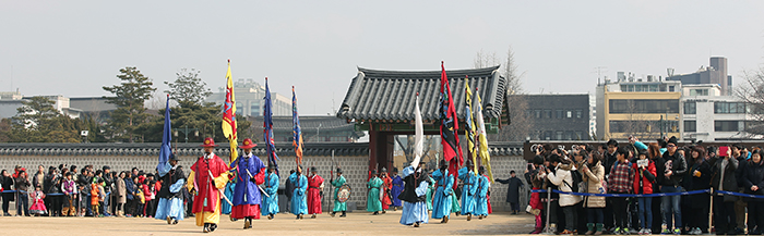  Families and international tourists wearing Hanbok, traditional Korean attire, watch the changing of the guards at Gyeongbokgung Palace on February 19. 