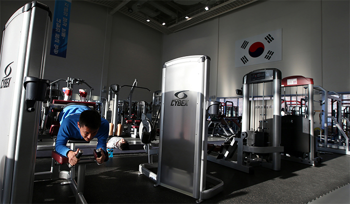 Athletes train hard for the upcoming Rio 2016 Olympics at the weight training center.