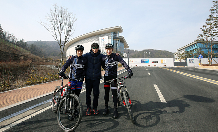 Korea Triathlon National Team members Heo Min-ho (left) and Kim Ji-hwan (right) pose for a photo with their head coach, Shin Jin-seop, in front of the Jincheon National Training Center in Chungcheongbuk-do Province. 
