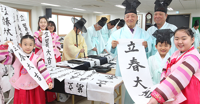 Spanning the generations, people celebrate the traditional first day of spring, <i>Ipchun</i>, which falls on Feb. 4 this year.