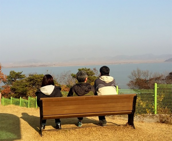 Visitors sit at a bench in front of the Reunification Hope Center.