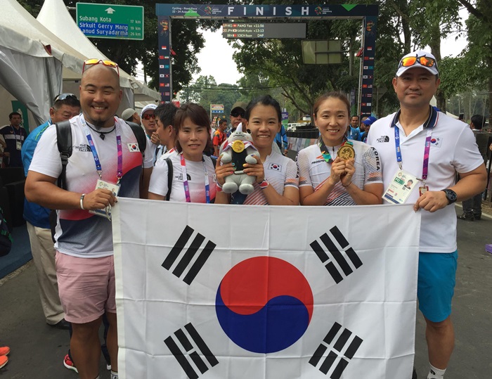 Cycling Road gold medalist Na Ahreum (second from right) and Korean delegation team hold Taegeukgi Korean national flag after winning the gold medal in the women’s 100km Indv. Road Race Final, on Aug. 22. (Yonhap News)