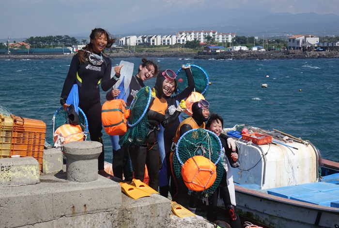 Some of Jeju's famous female haenyeo divers and a group of Taiwanese visitors pose for a photograph at the Jeju Hansupul Hanyeo School on Aug. 2. (Jeju Tourism Organization)