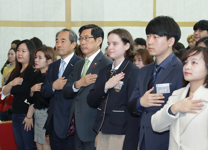 Newly naturalized Koreans citizens on Jan. 21 salute the national flag with Justice Minister Park Sang-ki (front row, fourth from the right) in a ceremony at National Hangeul Museum in Seoul’s Yongsan-gu District.
