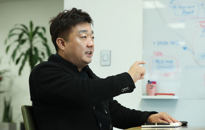 I-Brics CEO Chae Jong Hyun on Dec. 26, 2018, explains at his office in the Pangyo-dong neighborhood of Seongnam, Gyeonggi-do Province, about his company’s curator robot CuAi. The device uses a leading AI technology for natural language understanding. (Kim Sunjoo)