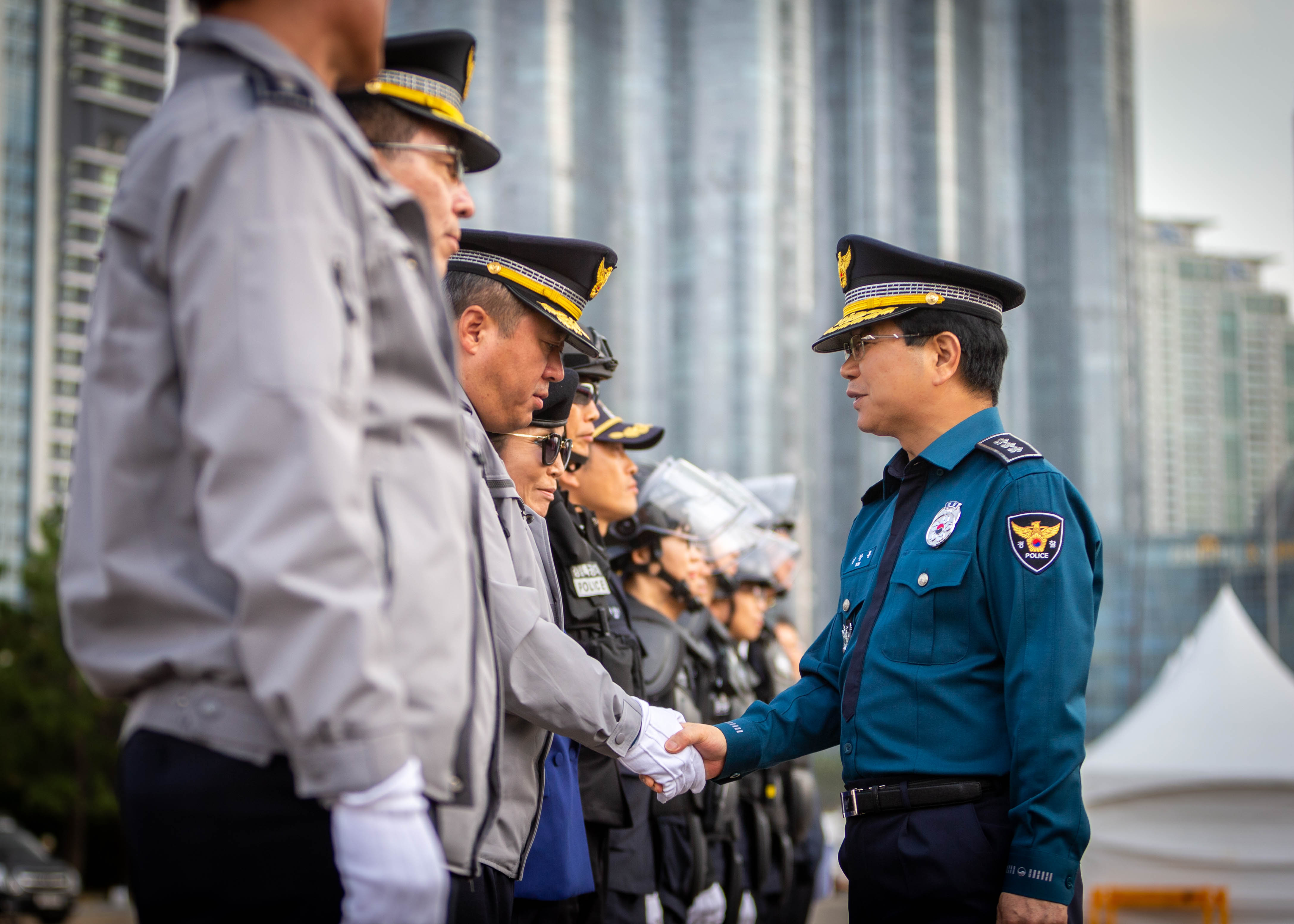 Kim Chang-yong, commissioner of the Busan Metropolitan Police Agency, on Oct. 30 shakes hands with members of the Police Guard Security Group at the latter's launching ceremony.