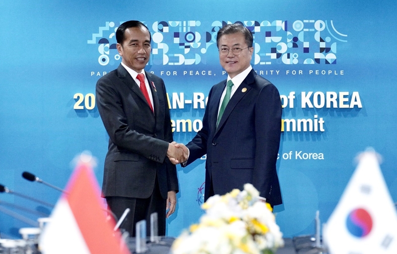 President Moon Jae-in (right) on Nov. 25 shakes hands with Indonesian President Joko Widodo before their bilateral summit in Busan.