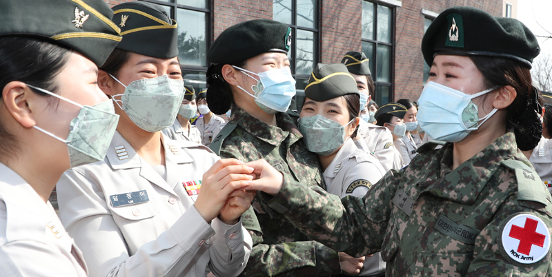 국군사관학교 60기 간호장교들이 3일 대전 유성구 국군간호사관학교에서 열린 졸업 및 임관식을 마친 뒤 대구지역의 신종 코로나바이러스 감염증(코로나19) 의료 지원을 위해 버스에 탑승 하며 후배 생도과 인사 나누고 있다. 대전=양동욱 기자