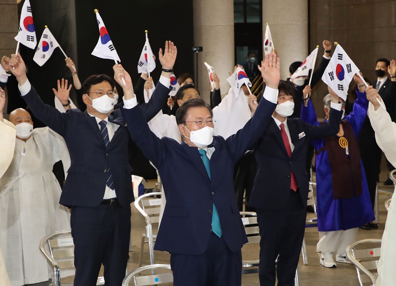 Le président Moon Jae-in et les participants lèvent les deux bras avec le drapeau de la Corée du Sud à la main, lors de la cérémonie du 76ème anniversaire du Jour de la Libération qui s’est tenue le 15 août à la Culture Station Seoul 284, dans le centre Séoul.