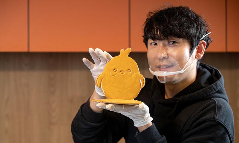 Dalgona artist Yoon Cheol poses with his rendition of the KOCIS mascot Kocnoni during an interview at Korea.net's open studio in Seoul's Jongno-gu District. (Kim Sunjoo)