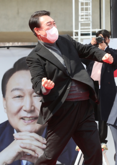 Presidential candidate Yoon Suk Yeol on March 8 asks for the people's support in front of Oncheoncheon Stream in Busan's Yeonje-gu District the day before the election and performs his trademark 