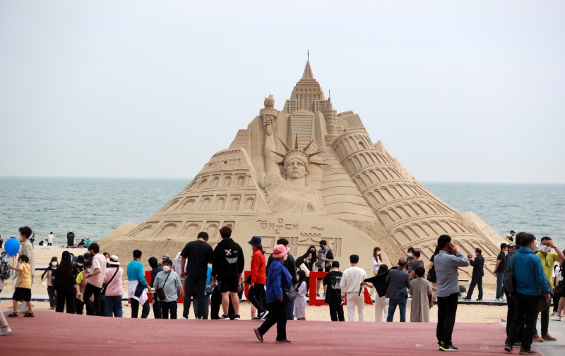 People on May 20 view a massive sand castle on the opening day of the Haeundae Sand Festival at Busan's Haeundae Beach.