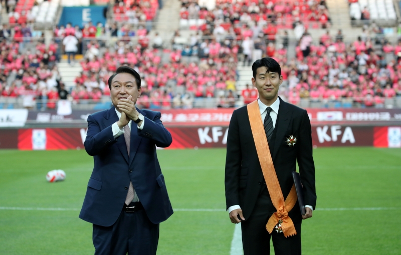 President Yoon Suk Yeol on June 2 claps after giving the Cheongnyong Medal to Son Heung-min, a star striker for Tottenham Hotspur of the English Premier League, at Seoul World Cup Stadium in the city's Mapo-gu District, where a friendly match between the national soccer team and Brazil was played