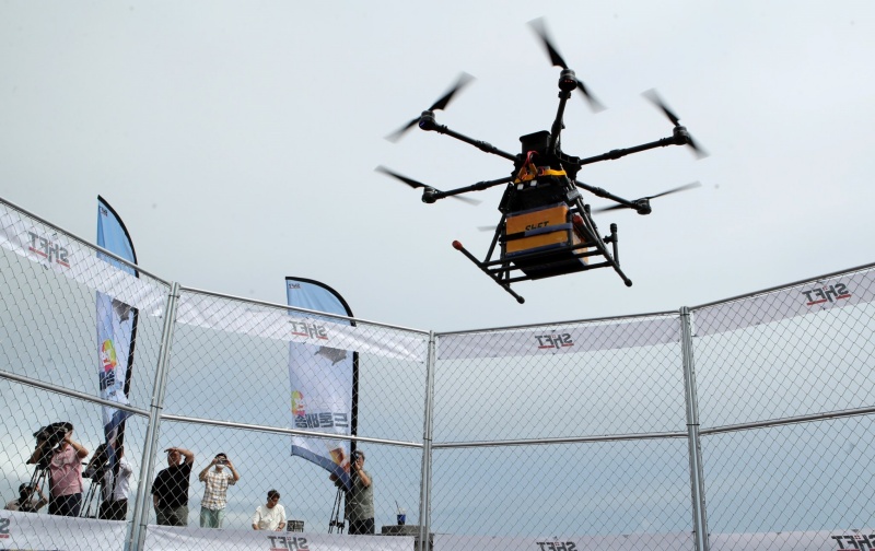 A drone on July 28 delivers an order of chicken and pizza to Mangsang Beach in Donghae, Gangwon-do Province. The provincial and Donghae governments teamed up with a domestic company to launch a pilot project for autonomous flying drone delivery that connects Mangsang Auto Camping Resort with stores at Mangsang Beach. Food will be delivered free to users at the beach for a month 
