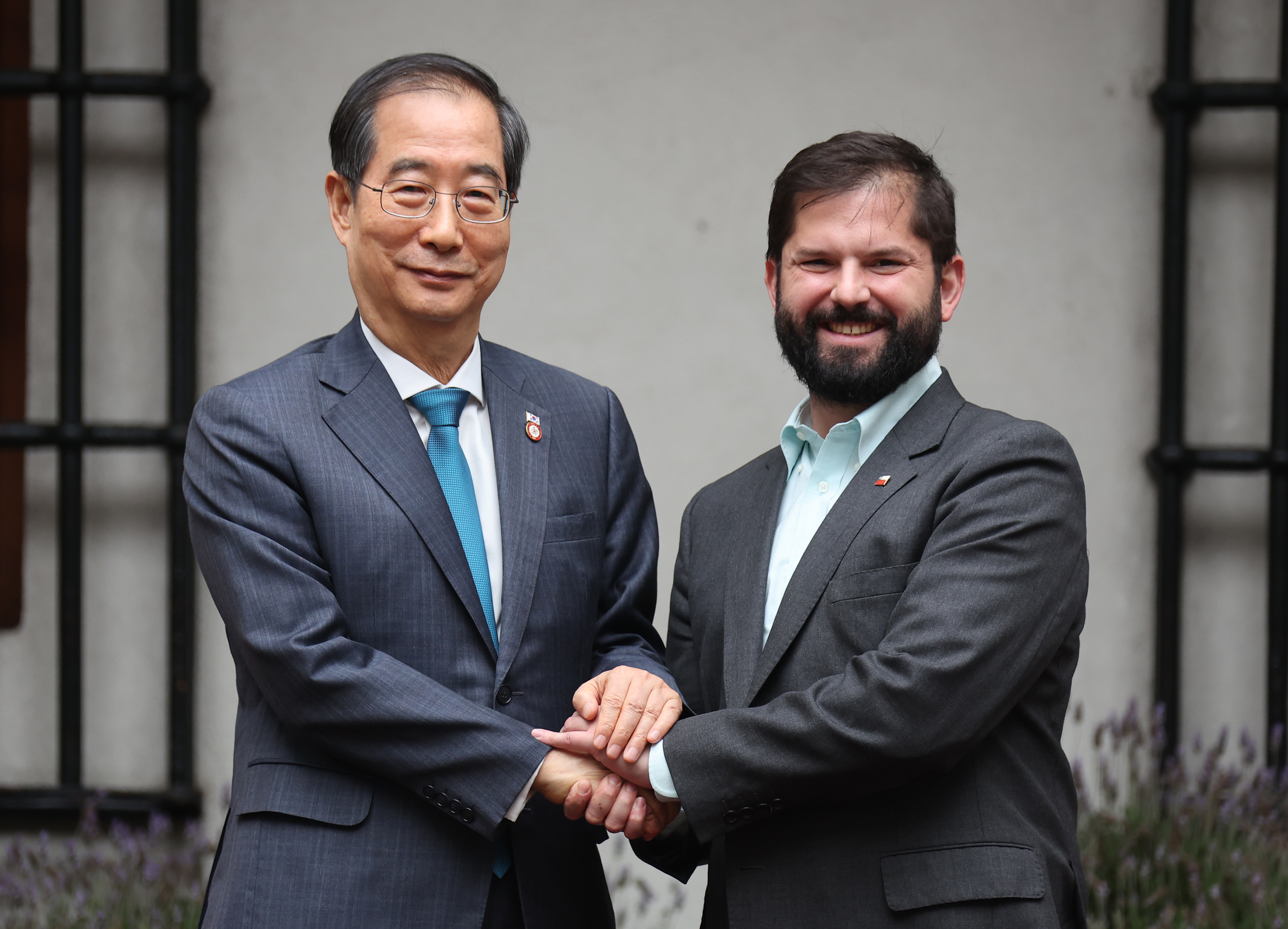 Prime Minister Han Duck-soo (left) and Chilean President Gabriel Boric Font on Oct. 11 pose for photos at the presidential palace in Santiago, Chile. 