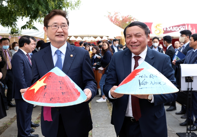 Minister of Culture, Sports and Tourism Park Bo Gyoon (left) on Oct. 16 and Vietnamese Minister of Culture, Sports and Tourism Nguyen Van Hung each hold a version of the traditional Vietnamese hat non la at the 2022 Culture Bridge Festa held at Yeouido Hangang Park in Seoul's Yeongdeungpo-gu District. 