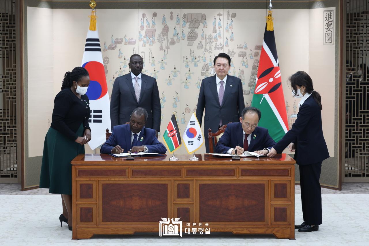 President Yoon Suk Yeol and Kenyan President William Ruto on Nov. 23 attend the signing event for an agreement on Korea raising its loan ceiling for Kenya to USD 1 billion from the Economic Development Cooperation Fund for 2022-26 at the Office of the President in Seoul's Yongsan-gu District. Both leaders watch Deputy Prime Minister and Minister of Finance and Economy Choo Kyung-ho (second from right) and Kenyan Minister of Finance Njuguna Ndung’u (second from left) sign the deal. 