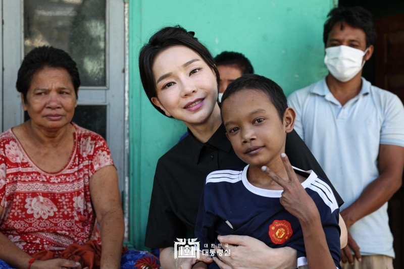 First lady Kim Keon Hee on Nov. 12 takes a photo with Aok Rotha, a Cambodian boy with congenital heart disease, at his house in Phnom Penh, Cambodia. (Office of the President) 