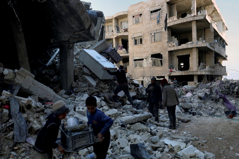 Residents of Ginderis, a town in Syria's Aleppo province, on Feb. 7 pull out furniture and home appliances from the rubble of a building that collapsed due to the catastrophic earthquake that hit the day before. (Yonhap News)