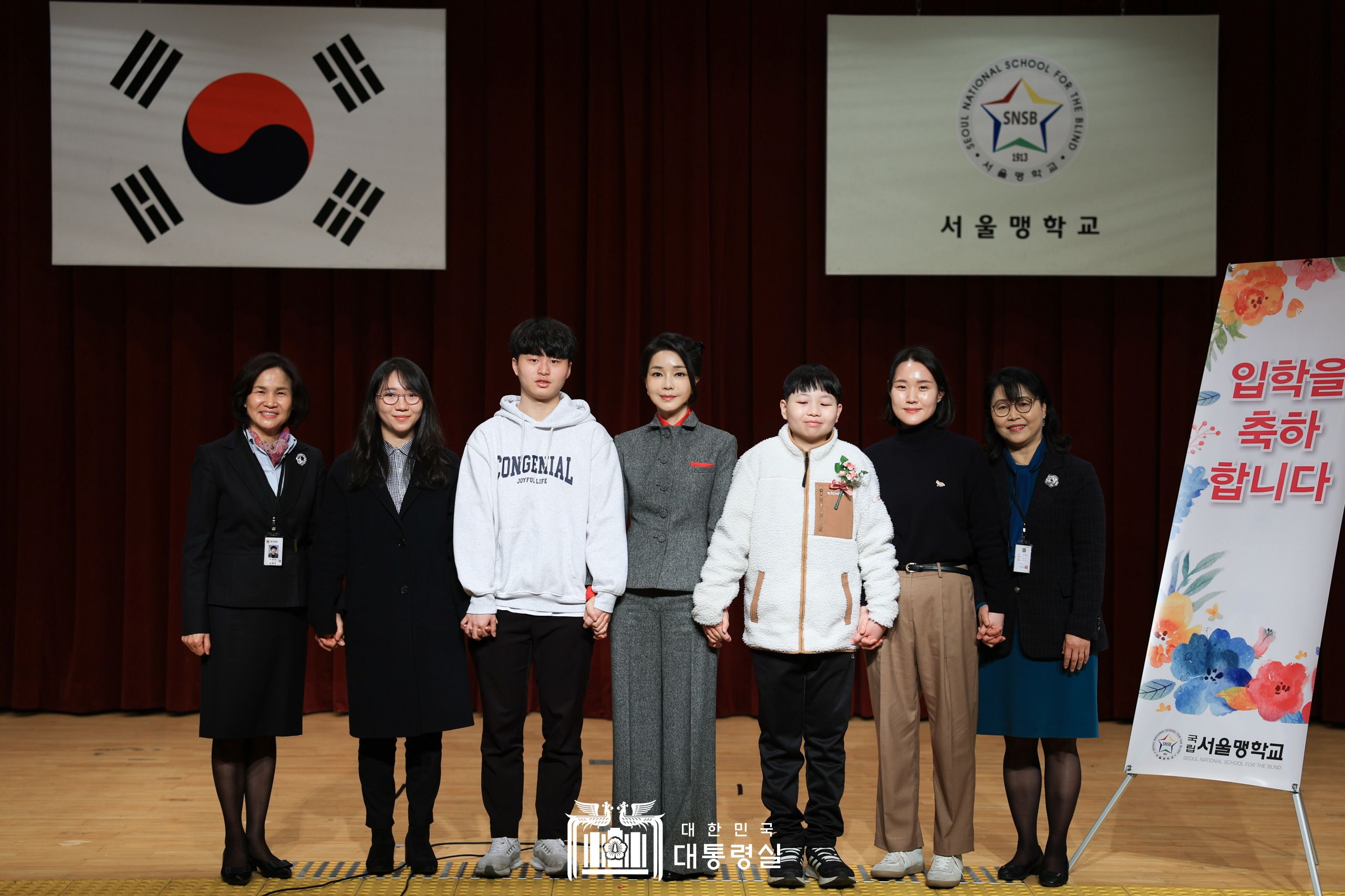 First lady Kim Keon Hee (center) on March 2 takes a group photo with teachers and students at the entrance ceremony of Seoul National School for the Blind in the capital's Jongno-gu District. (Office of the President)