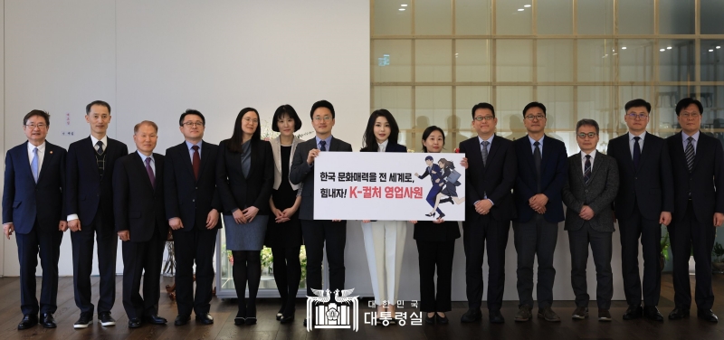 First lady Kim Keon Hee (center) on March 15 poses for photos with the directors of Korean Cultural Centers abroad and cultural promotion officials after hosting a luncheon for them at the official presidential residence in the Hannam-dong neighborhood of Seoul's Yongsan-gu District. She is holding a placard with a drawing of webtoon characters dubbed 