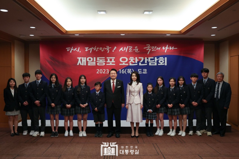 President Yoon Suk Yeol (eighth from left) and first lady Kim Keon Hee (ninth from left) on March 16 pose for a group photo with a student choir from Tokyo Korean School at a luncheon roundtable with ethnic Korean residents of Japan at the Imperial Hotel in Tokyo. In the first event of his visit, he thanked and gave the students words of encouragement, saying, (The community of ethnic Korean residents of Japan has been a strong supporter of our country whenever their homeland was in need, and its members contributed to raising Korea's status in Japan by actively working in their respective fields without losing their pride even under difficult conditions.)