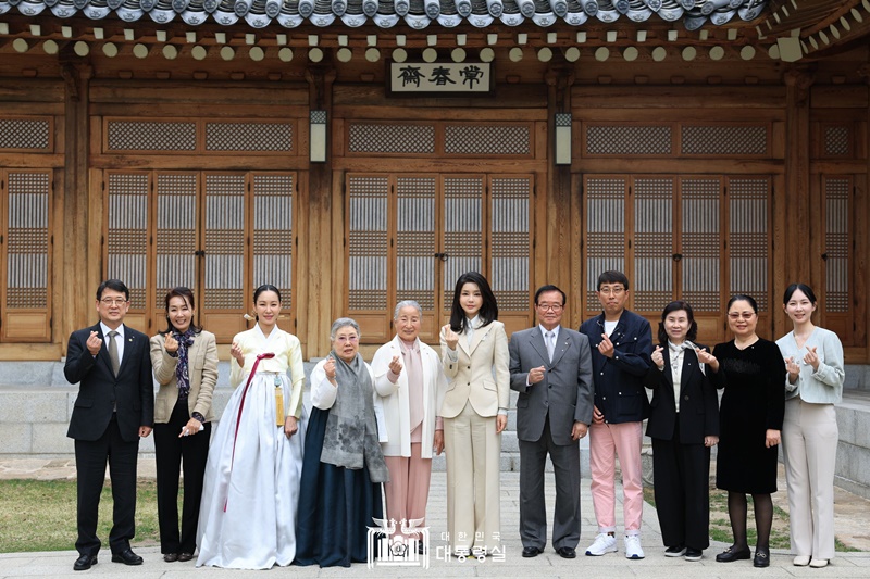 First lady Kim Keon Hee (center) on April 4 poses for photos with masters of intangible cultural heritage in traditional performing arts at Sangchunjae, the guesthouse of Cheong Wa Dae. (Office of the President) 