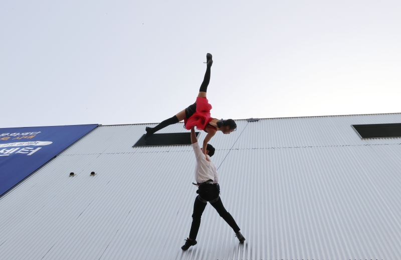 The vertical dance and air performing group Creative Dandi on the afternoon of April 12 puts on a show with ropes tied around the waist on the external wall of Seoul Theater Center in the capital's Jongno-gu District.