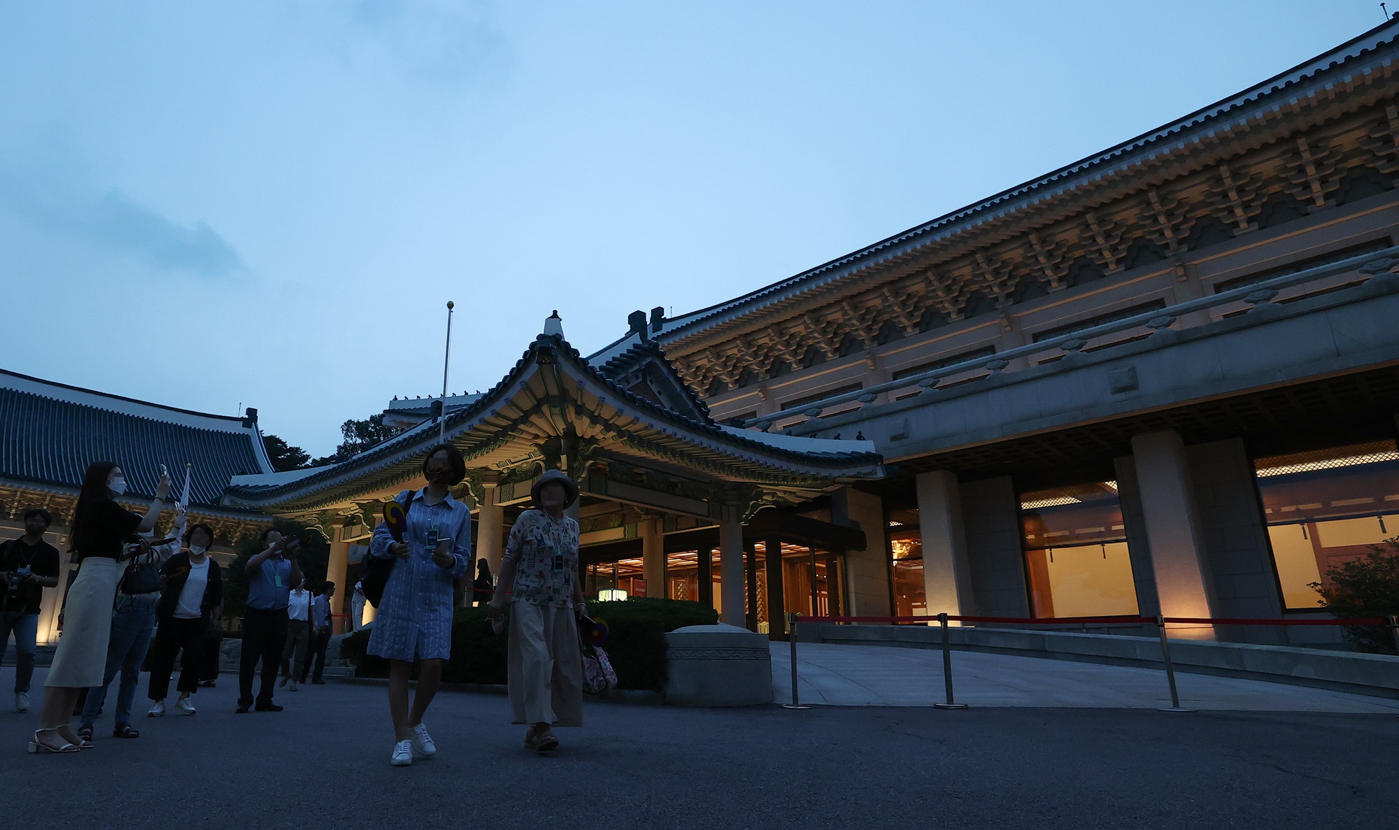 Participants at an open media event for an evening tour of Cheong Wa Dae on July 19, 2022, walk around the main building. (Yonhap News) 