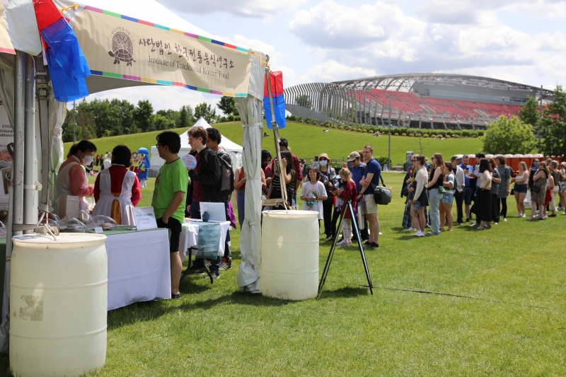 Visitors to K-Fest on June 10 queue up to sample Korean food at a booth set up by the Institute of Traditional Korean Food at Lansdowne Park in Ottawa, Canada. 