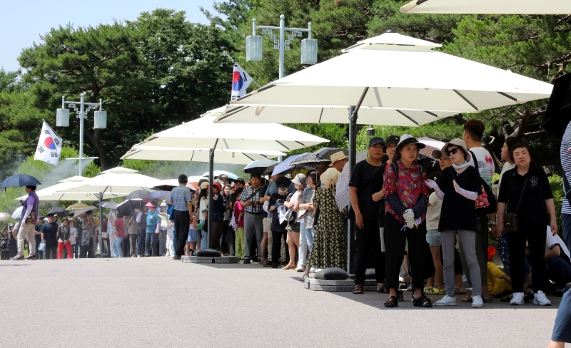 Visitors on June 17 wait in line outside to enter the exhibition's venue at the main building of Cheong Wa Dae. 