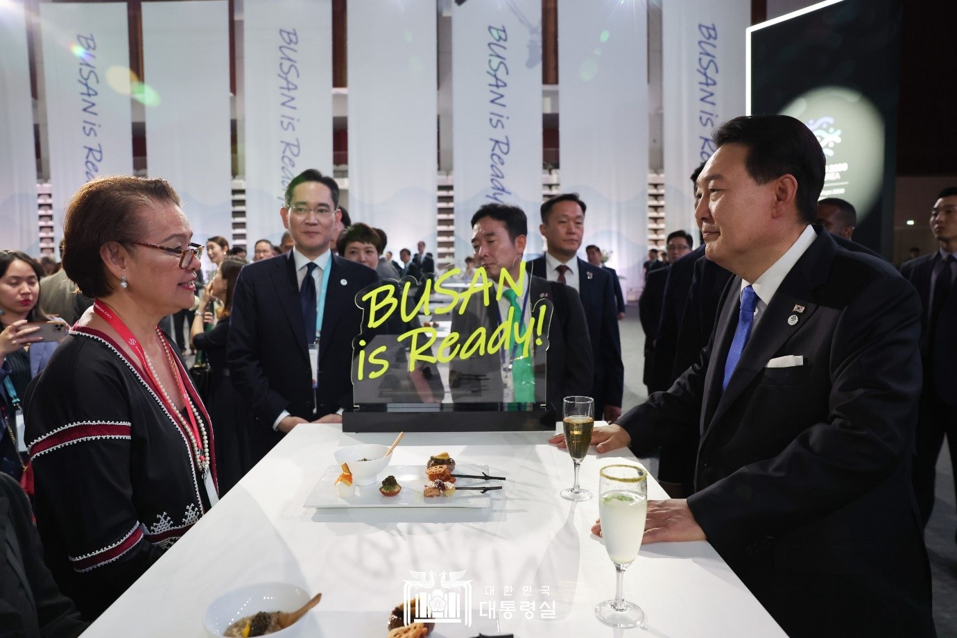 President Yoon Suk Yeol on June 21 greets attendees at an official reception for the 2030 Busan World Expo at a sports center in the Paris commune Issy-les-Moulineaux. Delegations there received a commemorative stamp packet featuring K-pop sensation BTS, who is promotional ambassador for Busan's bid, and keychains that the first lady helped design with the phrase 