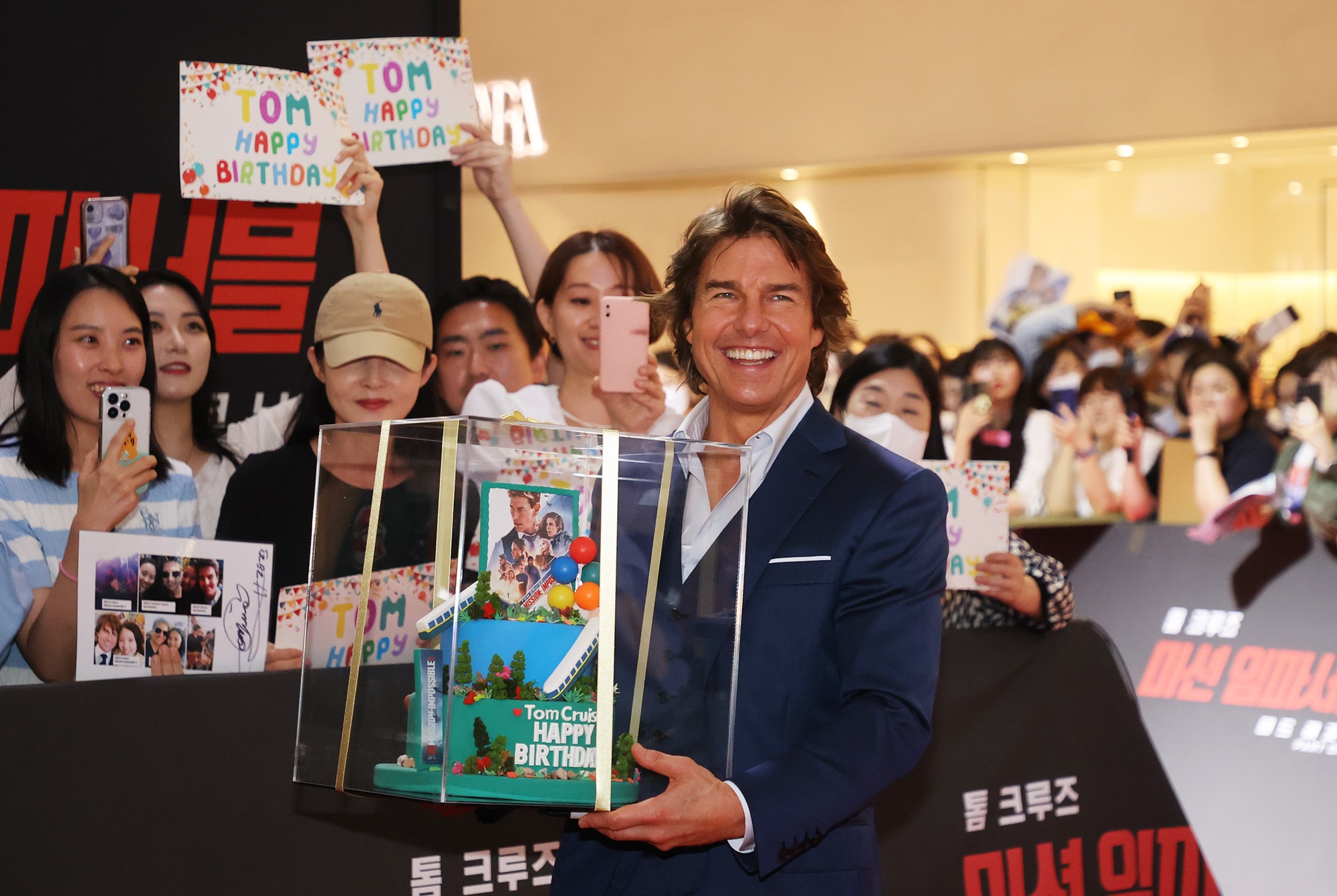 Actor Tom Cruise on June 29 receives a birthday cake from fans at a red carpet event for the premiere of 