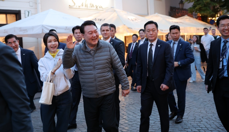 President Yoon Suk Yeol and first lady Kim Keon Hee on July 10 greet U.S. Sen. Pete Ricketts, a Republican from Nebraska, at a restaurant while taking a walk in the old town of Vilnius, Lithuania. (Yonhap News) 