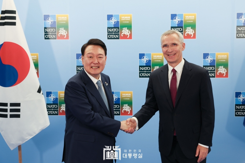 President Yoon Suk Yeol (left) and NATO Secretary General Jens Stoltenberg on July 11 exchange a handshake at Lithuanian Exhibition and Congress Centre, aka LITEXPO, the venue of the NATO Summit in Vilnius, Lithuania. 