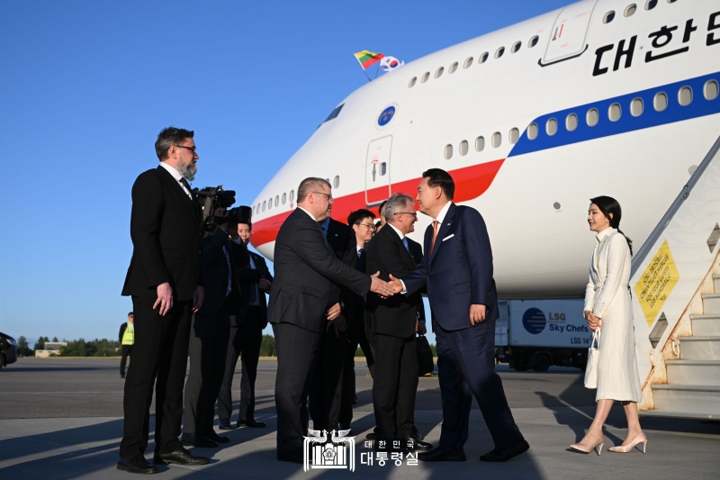President Yoon Suk Yeol (second from right), accompanied by first lady Kim Keon Hee (right), on the afternoon of July 10 shakes hands with welcoming officials upon arrival at Vilnius International Airport in Vilnius, Lithuania. 