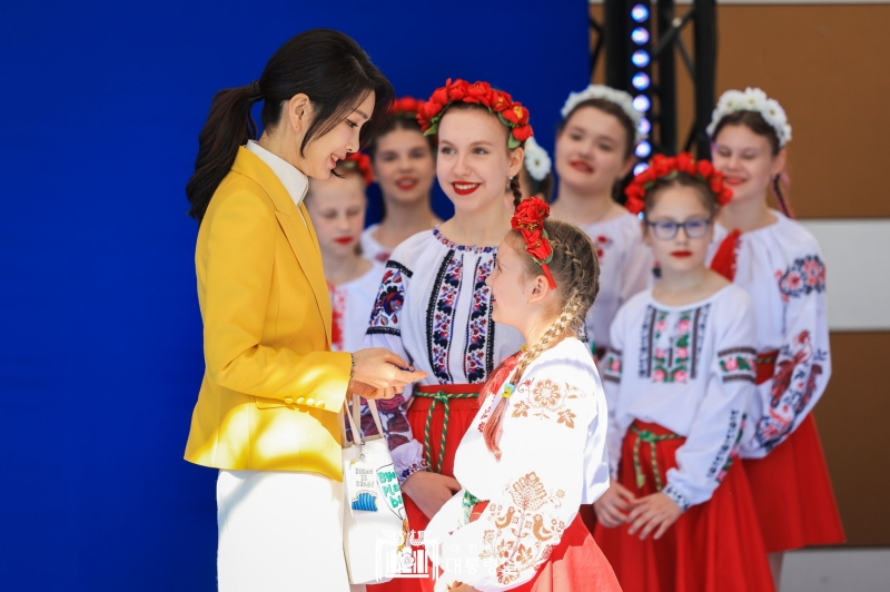 First lady Kim Keon Hee (left) on July 12 receives souvenirs from Ukrainian children at an official program for the spouses of NATO leaders at the Ukrainian Center in Vilnius, Lithuania.