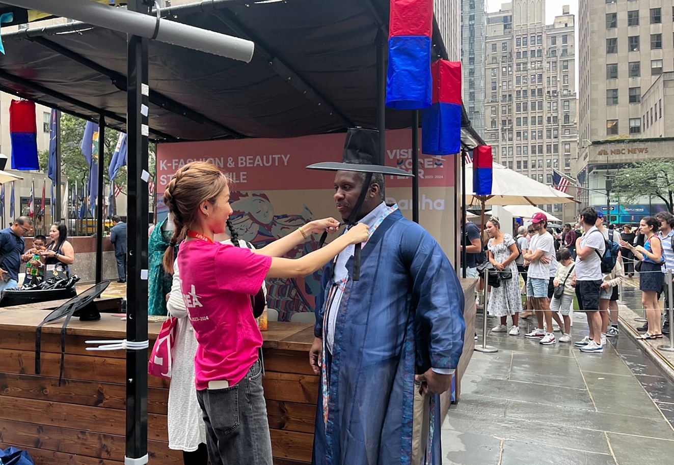 Visitors at the event try on Hanbok (traditional clothes) at a promotional booth in NY's Rockefeller Center. .