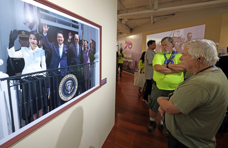 The American delegation to the 25th World Scout Jamboree in Korea on Aug. 10 looks at photos with audio descriptions at an exhibition marking the 70th anniversary of Korea's alliance with the U.S. at the National Museum of Korean Contemporary History in Seoul's Jongno-gu District.