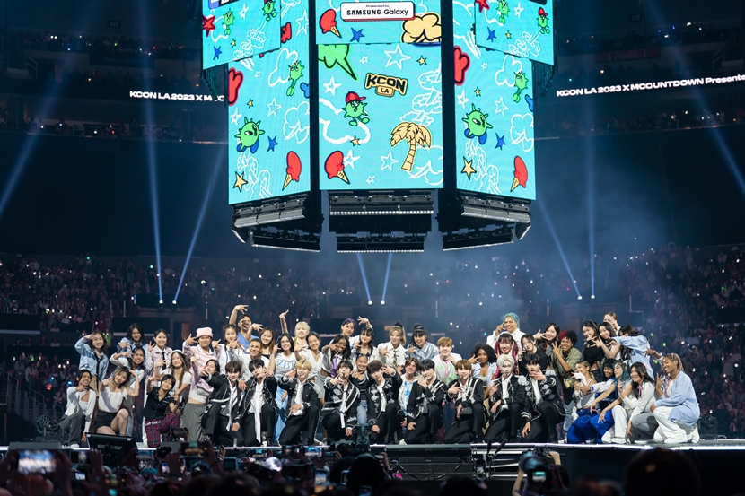 The 21 K-pop acts who performed at this year's KCON LA on Aug. 19 pose for a group photo at Crypto.com Arena in Los Angeles. 