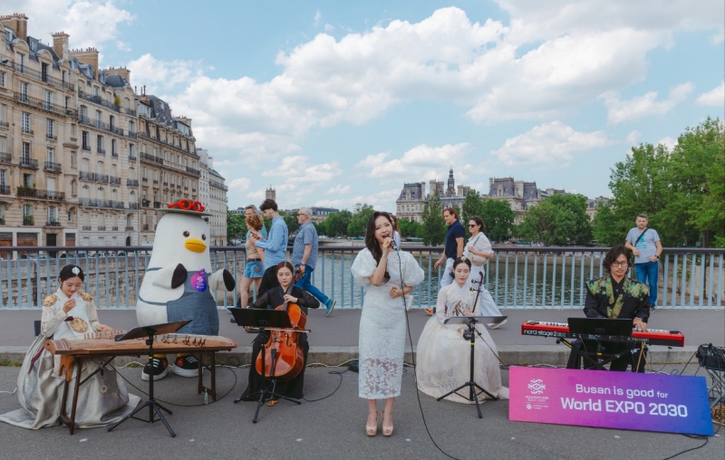 The fusion gugak (traditional music) group Hwasumok on Aug. 6 holds a busking performance on a bridge across the Seine River in Paris to promote Busan's bid to host the 2030 World Expo. (Busan Metropolitan City) 