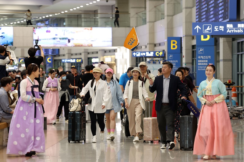 Members of a Chinese tour group arranged by the Korea Tourism Organization to mark the 31st anniversary of diplomatic ties between Korea and China on Aug. 24 receive a warm welcome upon arrival at Terminal 1 of Incheon International Airport. (Yonhap News) 