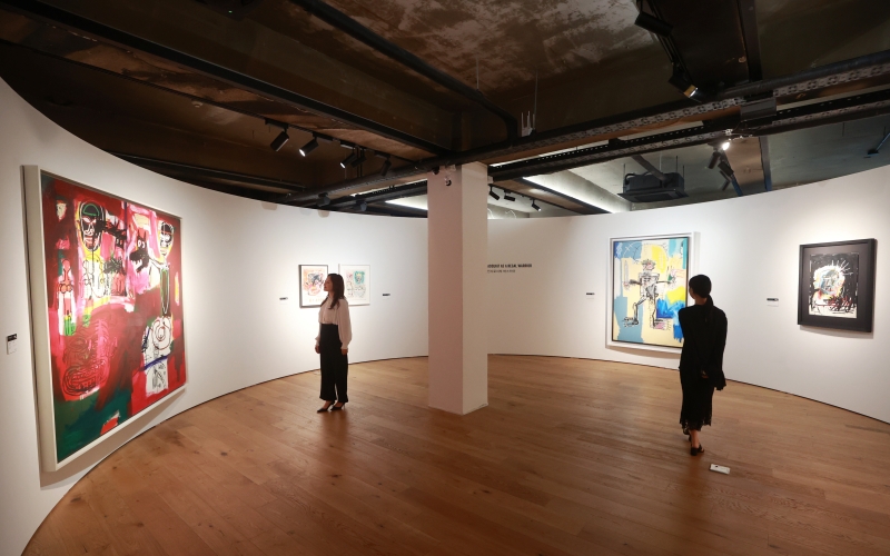Visitors on Sept. 4 look at works in a preview event for the exhibition 