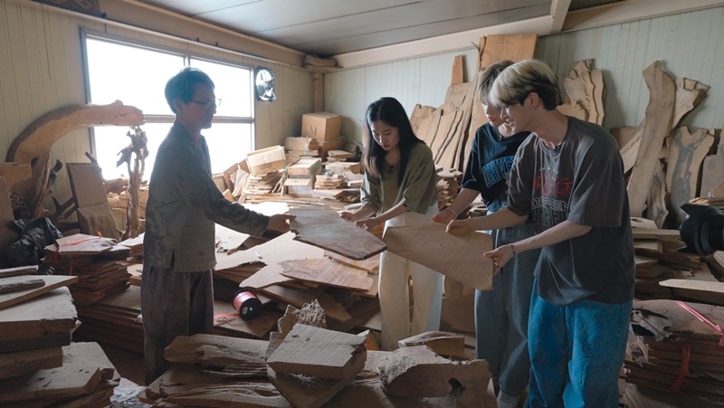 Somokjang (joinery artisan) Jeong Jin-ho (left) on Sept. 2 explains categorizing wood to make furniture to Korea.net staff writer Cao Thi Ha (second from left) and K-pop boy band XODIAC members Leo (right) and Gyumin at Jeong's work space in the township of Myeongseok-myeon in Jinju, Gyeongsangnam-do Province. (OSSC Production Team) 