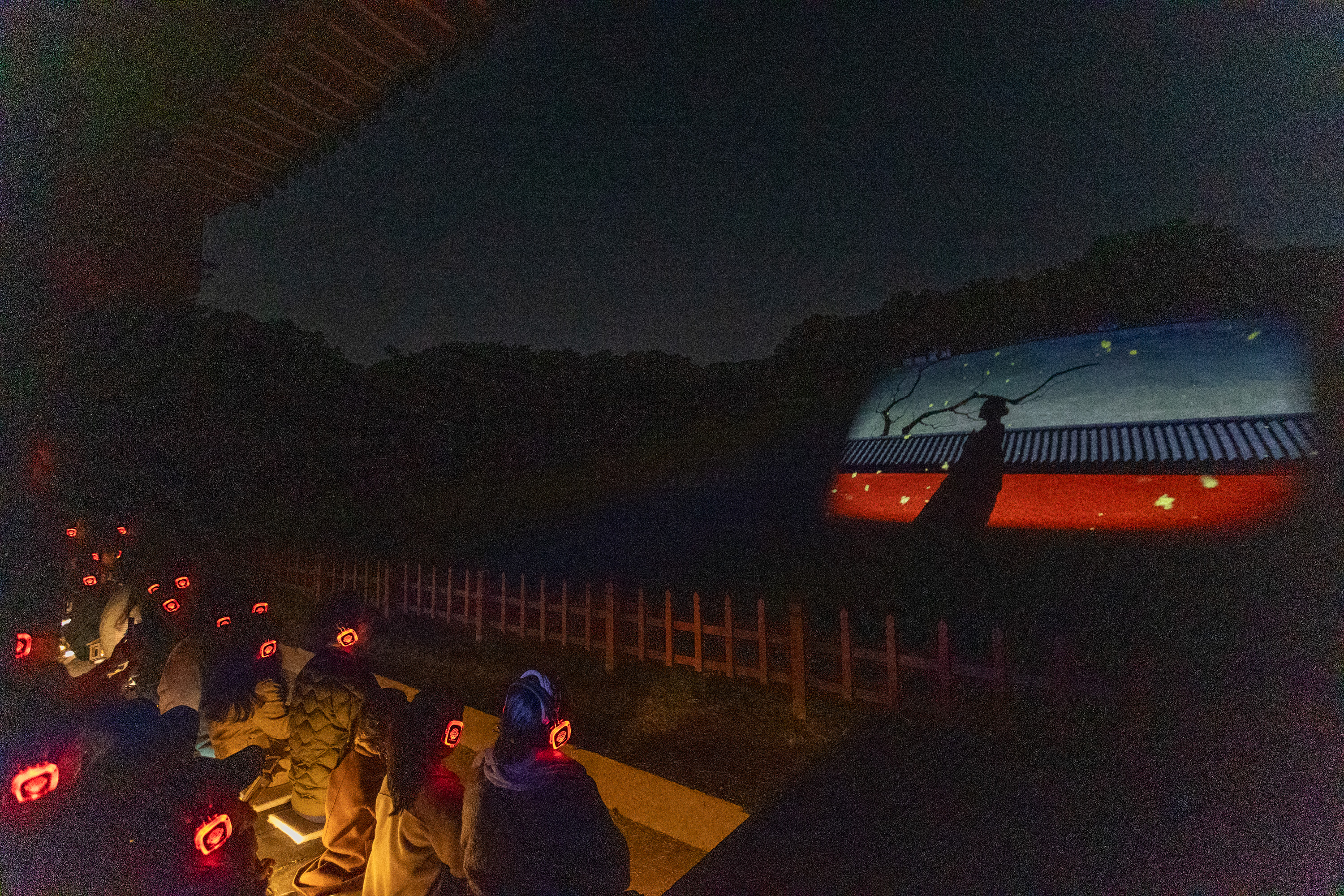 Visitors on the Seooreung Night Tour on Oct. 16 watch a radio drama on the background screen of Myeongneung, the twin graves of King Sukjong and Queen Inhyeon, at the Royal Tombs of the Joseon Dynasty in Goyang, Gyeonggi-do Province. 